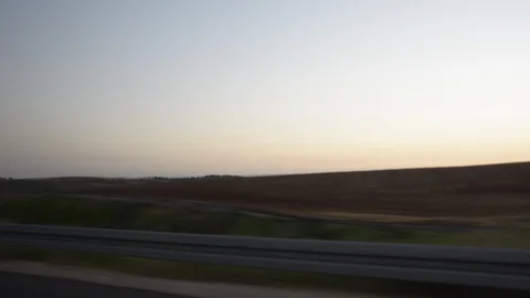 Driving plate side view moving through hills and fields in sunset time 스톡 동영상 100085181