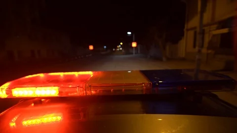 Driving police car with blue red emergency lights flashing at night Stock Footage