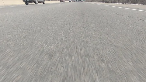Driving POV low angle fast to the pavement on highway with traffic Stock Footage 103072203
