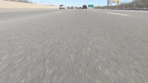 Driving POV low angle fast to the pavement on highway with traffic Stock Footage 103073770