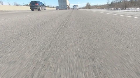 Driving POV low angle fast to the pavement on highway with traffic Stock Footage 103075578