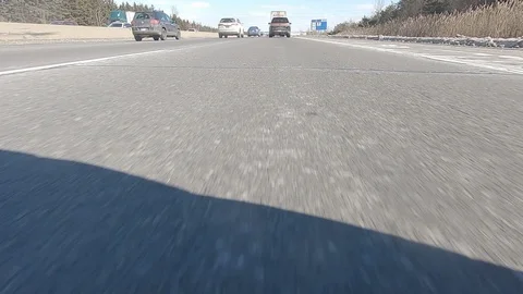 Driving POV low angle fast to the pavement on highway with traffic Stock Footage 103078723