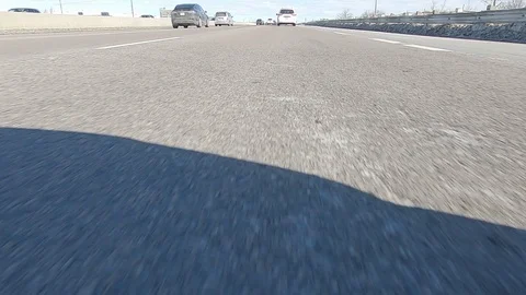 Driving POV low angle fast to the pavement on highway with traffic Stock Footage 103080630