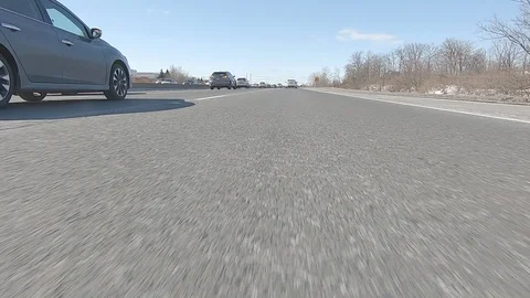 Driving POV low angle fast to the pavement on highway with traffic Stock Footage 103090650