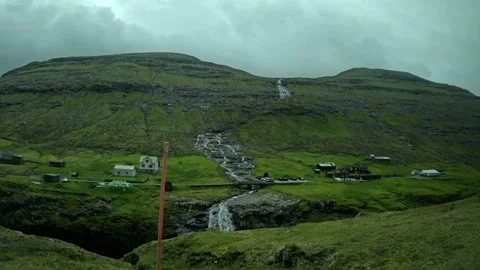 Driving POV past a remote mountain village with a waterfall, Faroe Islands Stock-Footage 339363966