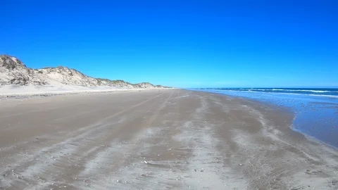 Driving POV sandy beach ocean waves and sand dunes 4K Stock-Footage 102476477