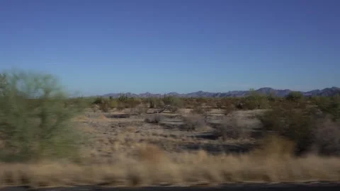 Driving POV from side window past desert scenery Stock Footage 254356308