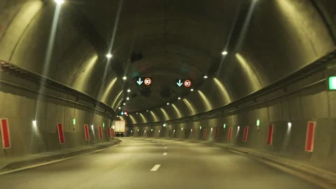 Driving pov through modern illuminated highway road tunnel Stock Footage 345638124