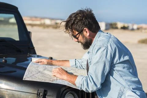 Driving problems. One man driver lost on the roads use paper old guide map .. Stock Photos