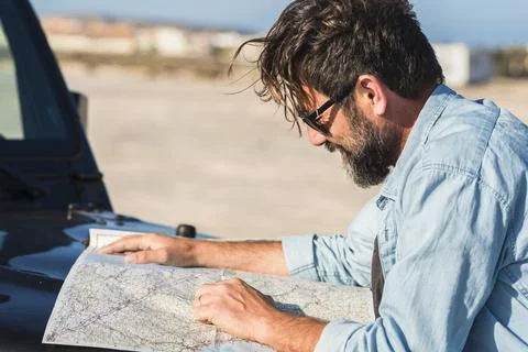 Driving problems. One man driver lost on the roads use paper old guide map .. Stock Photos