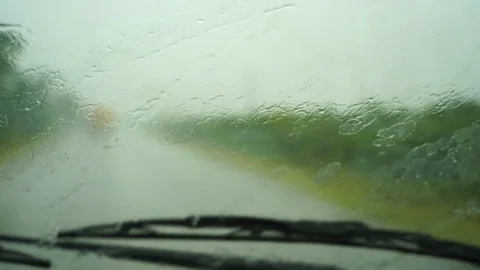 Driving in rain view from inside car with drops on car windshield. Slow motion Stock Footage 125479720