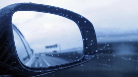 Driving in rainy day looking side mirror view Stock Footage