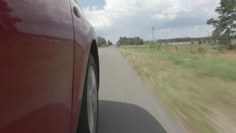 Driving a red car over the road along the asphalt at speed, view from the wheel. Video stock 135991903