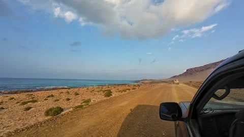 Driving on a remote coastal dirt road beside the sea Stock Footage 329028391
