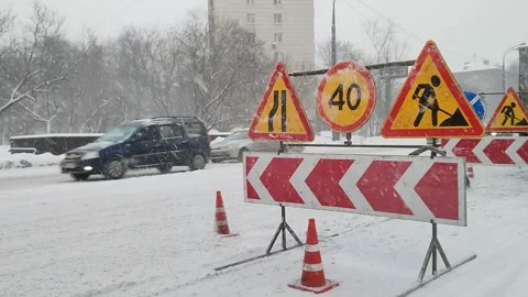Driving on road during heavy snowfall. Sign for repair work and detour on snow 스톡 동영상 260497045