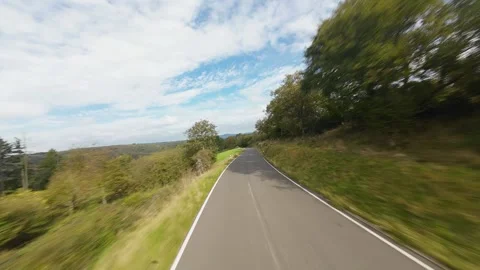 Driving road in the hills in the eiffel Germany. FPV aerial flying drone Stock Footage 288368394