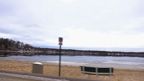 Driving on a road parallel to a small lake with many vacation homes on the Video stock 102016585