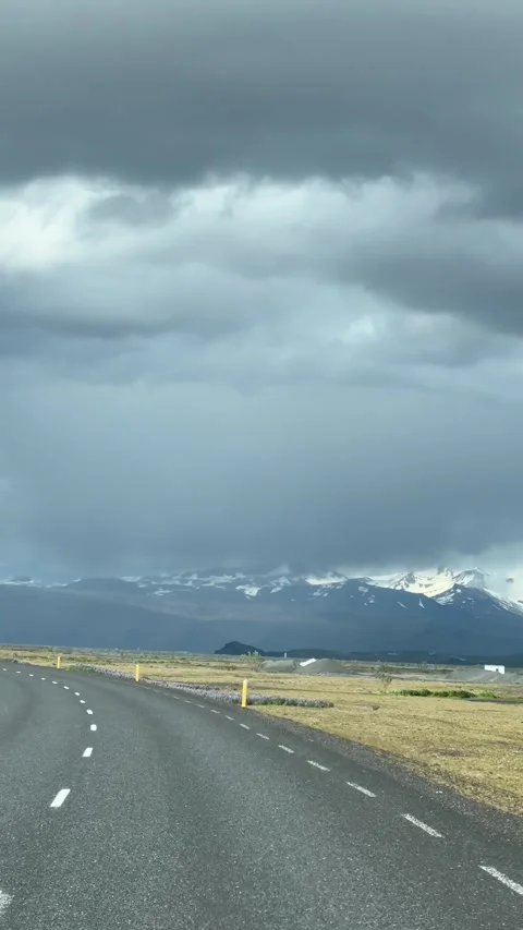 Driving on a road with snow-capped mountains in the background, Iceland Video stock 331533416