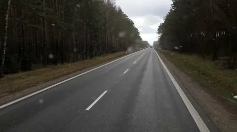 Driving on road through forest trees on cloudy day with windshield wipers POV Stock Footage 49669970
