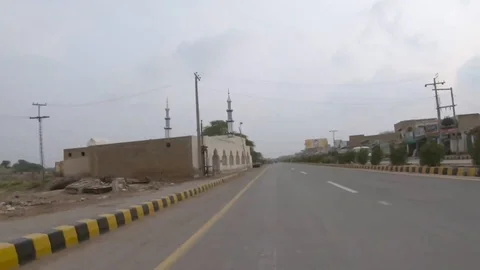 Driving on a road through a small town near Bahawalpur Pakistan Stock Footage 99727682