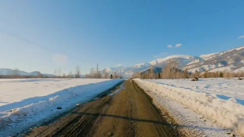 Driving on rural dirt road through snow covered mountain landscape wide shot Stock-Footage 346636394