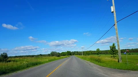 Driving Rural Road Along Farmland During Bright Summer Day Stock Footage
