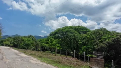 Driving Rural Road Past Wire Fence and Green Valley Stock Footage 341370464
