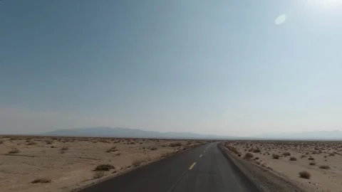 Driving shot on an empty desert highway stretching toward a hazy horizon Stock Footage 319794092