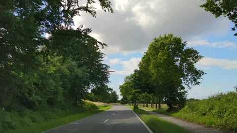 Driving shot through the windscreen of a car moving on a  green and tidy rura Video stock 143745721