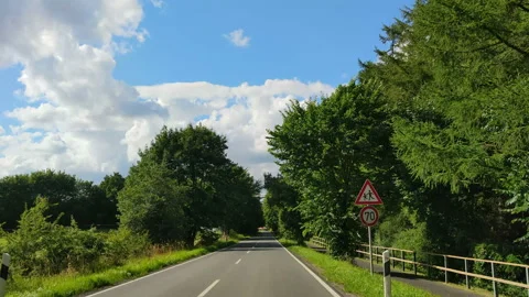 Driving shot through windscreen of car moving on green and tidy rural Stock Footage 143777434