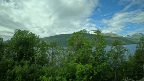 Driving side window view of coastal highway with fjord and mountains in Norway Vidéo 340960151