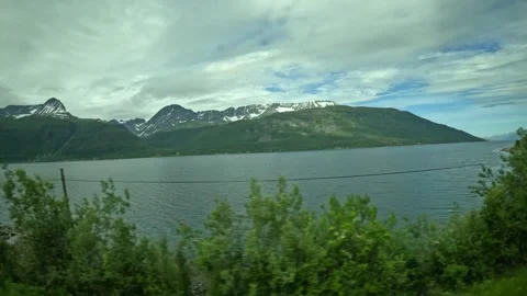 Driving side window view of fjord coastline and power lines in Northern Norway 動画素材 341272651