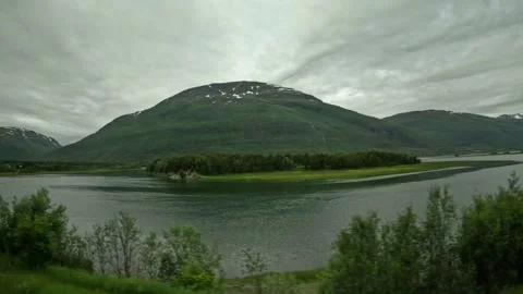 Driving side window view of fjord bay with small green islet in Northern Norway Stock-Footage 341272661