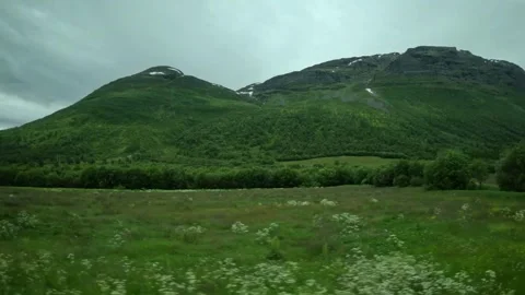 Driving side window view of green valley with hay bales and mountains in Norway Stock-Footage 341272665