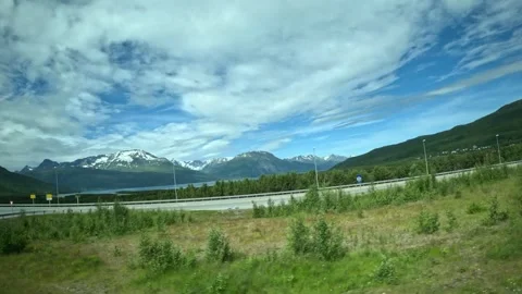 Driving side window view of highway and snow capped mountains in Northern Norway Stock-Footage 340960138