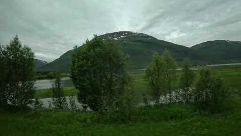 Driving side window view of lush wetlands and mountain valley in Northern Norway Stock-Footage 341272655