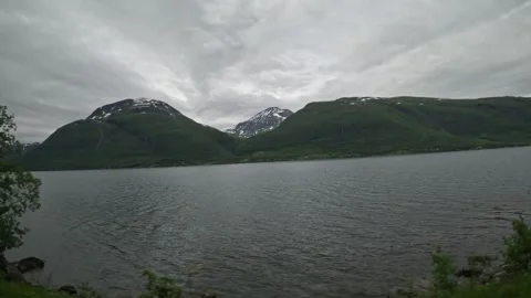Driving side window view offjord passing traditional Norwegian wooden houses Video stock 341272658