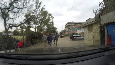 Driving slow behind people walking in the street in urban Africa Video stock 106902192