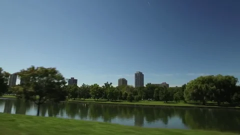 Driving by a small lake with buildings in the background in Chicago. Stock Footage 70707748