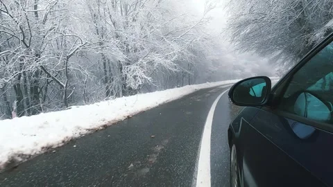 Driving on snow covered closed mountain road with pine tree forest Stock Footage 325616150