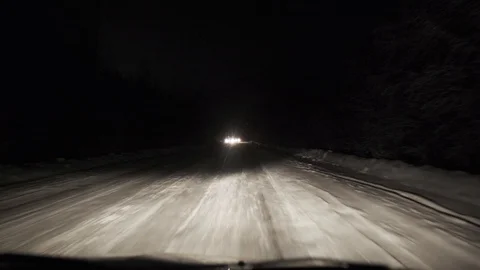 Driving on snow road in forest at night. POV Stock Footage 129555360