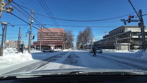 Driving at snowy intersection with pedestrian and truck in Asahikawa Japan 스톡 동영상 333314067