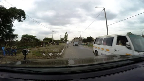 Driving through an African village behind a man on a bicycle Video stock 106912487