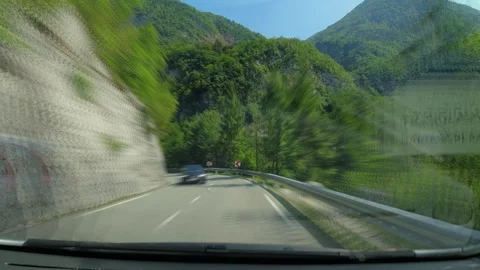Driving through an alpine valley between high mountains Stock Footage 259554719