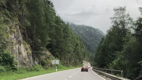 Driving through alpine valley on rainy road in Swiss Alps Switzerland Video stock 333306155