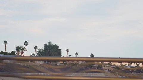 Driving through a bridge in Palm Desert looking at the homes and palm trees.  Stock Footage 107943273