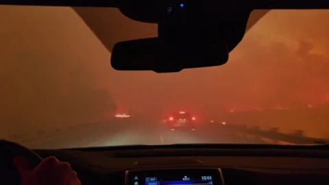 Driving through a dangerous wildfire on a highway at night Vídeos de archivo 332963108