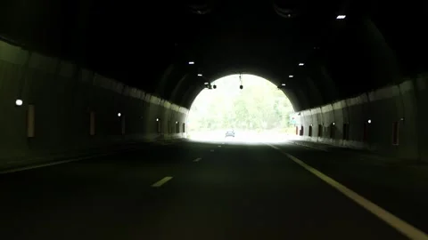 Driving through a dark highway tunnel towards the bright light at the end Stock Footage 345638088