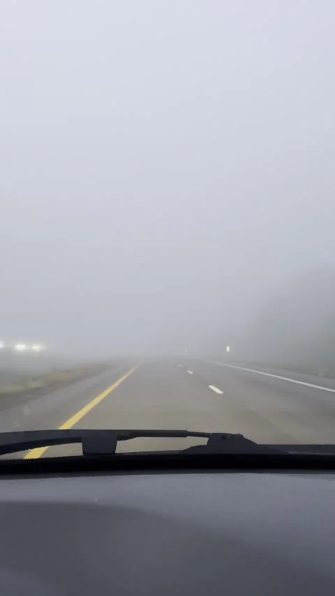 Driving through dense fog on an early morning journey down a quiet highway Stock Footage 295795280