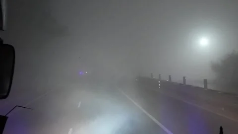 Driving through dense fog with poor visibility on highway at night Stock Footage 325564992